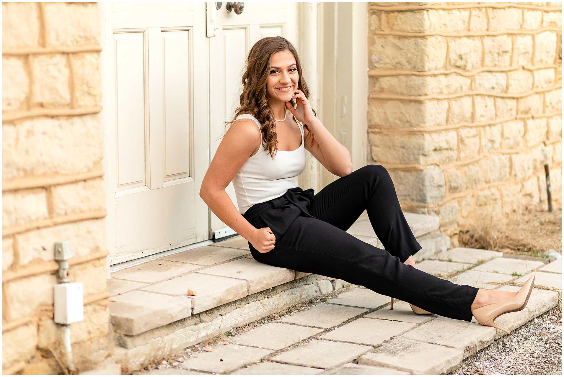Senior-Pictures-in-Downtown-Kankakee-Illinois-Sitting-by-Light-Brick-Wall